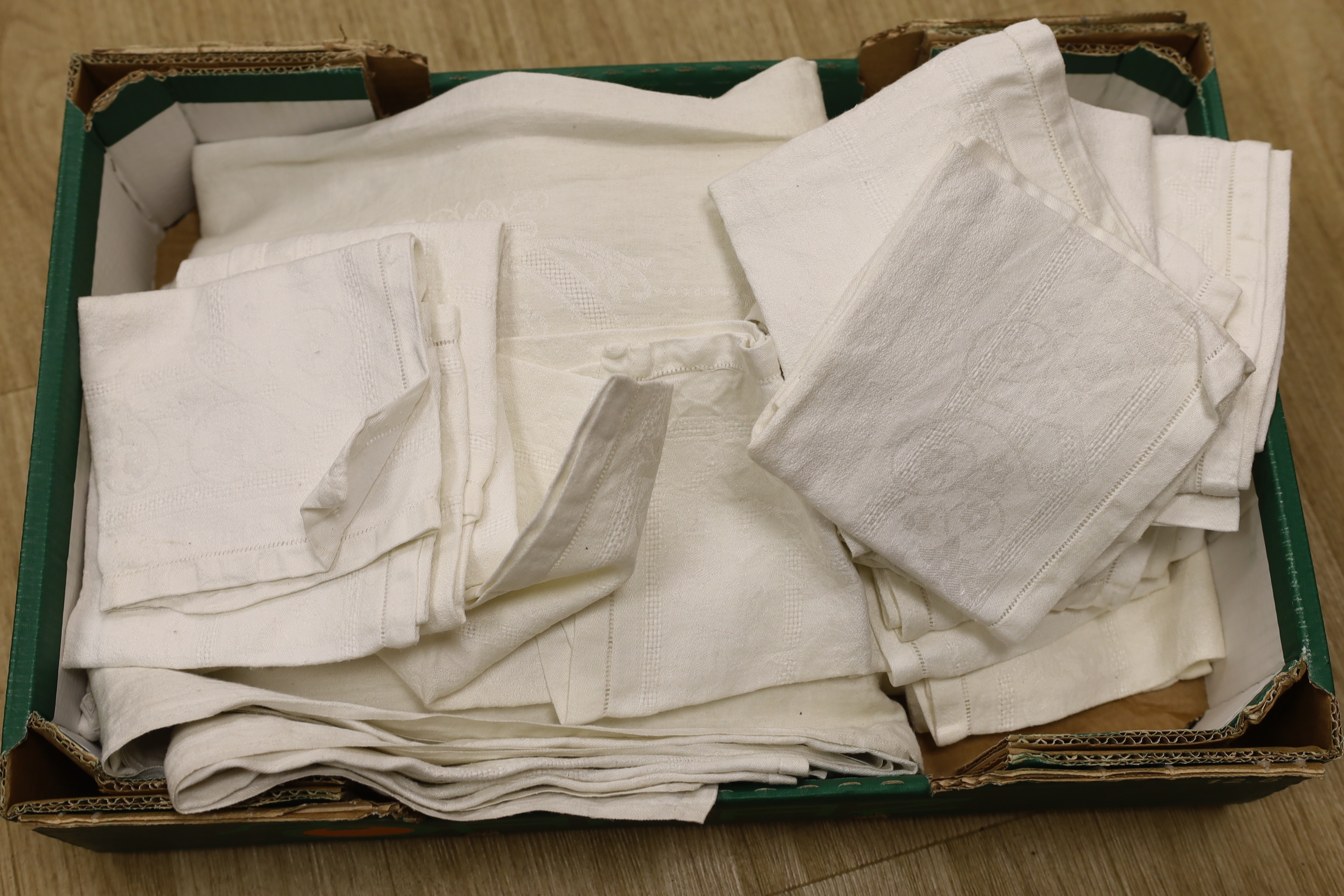 An early 20th century French damask table cloth with twelve matching napkins and three similar damask table cloths
